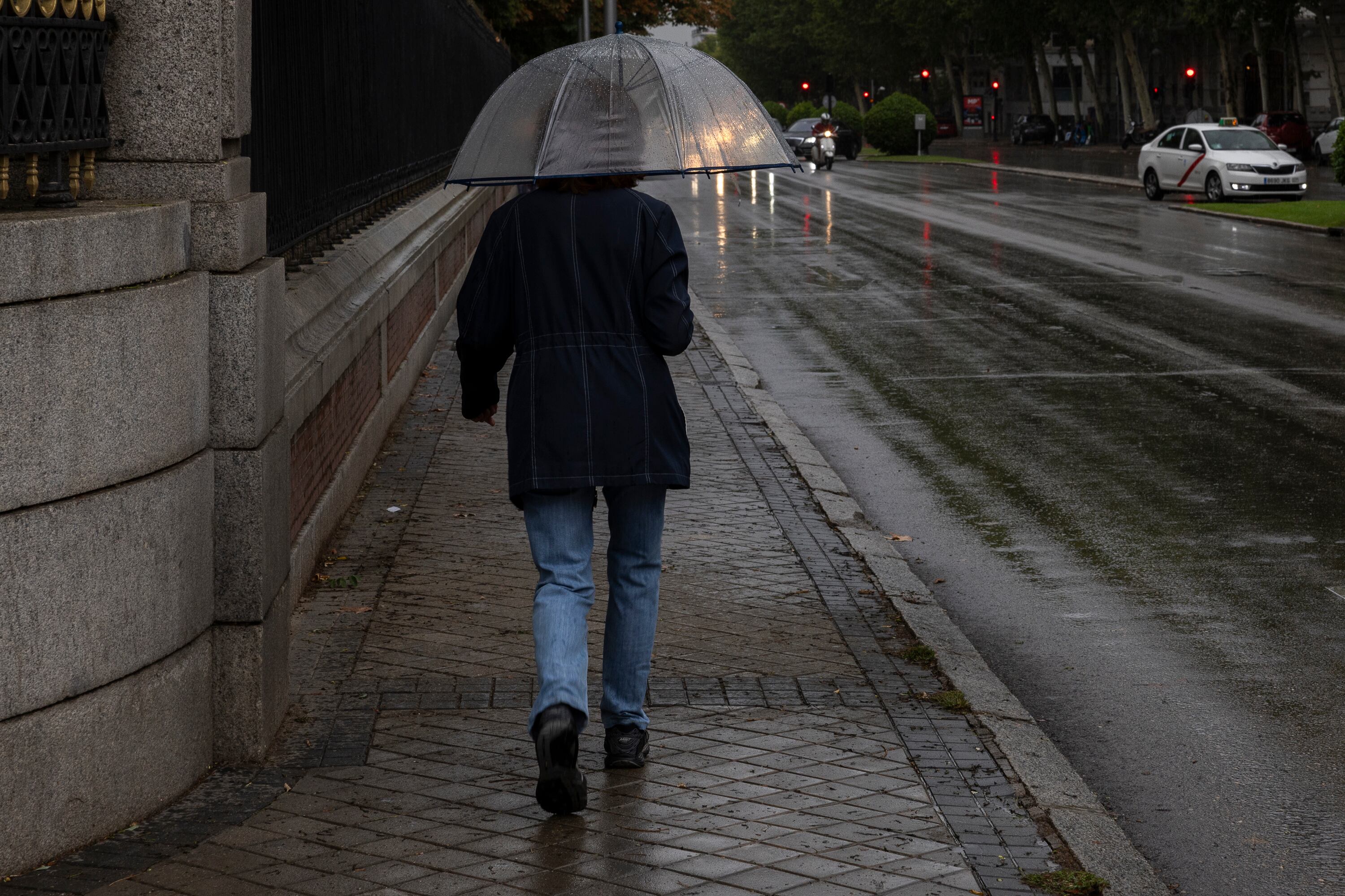 Una persona pasea por los alrededores del Parque del Retiro, cerrado por la alerta roja, este domingo en Madrid.