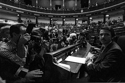 El Presidente del Gobierno, José María Aznar, aparece rodeado de periodistas en su escaño del Congreso, poco antes de iniciar el debate sobre el estado de la Nación.