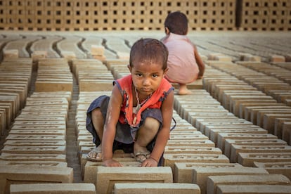 Unos niños de corta edad trabajan en un horno de ladrillos en la zona de Biratnagar, en Terai (Nepal), en noviembre de 2021.