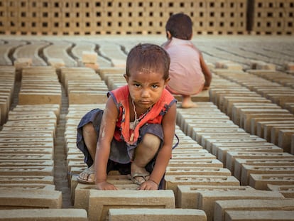 Unos niños de corta edad trabajan en un horno de ladrillos en la zona de Biratnagar, en Terai (Nepal), en noviembre de 2021.