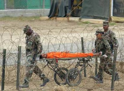 Soldados norteamericanos de la base de Guantánamo (Cuba) trasladan en camilla a uno de los presos tras un interrogatorio.