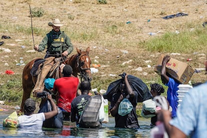 Un agente fronterizo amenaza con una soga a un grupo de migrantes en el río Grande, entre Texas y México, este 19 de septiembre.