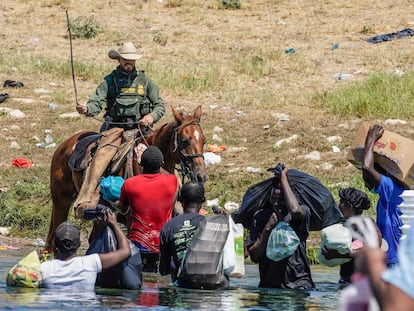 Un agente fronterizo amenaza con una soga a un grupo de migrantes en el río Grande, entre Texas y México, este 19 de septiembre.