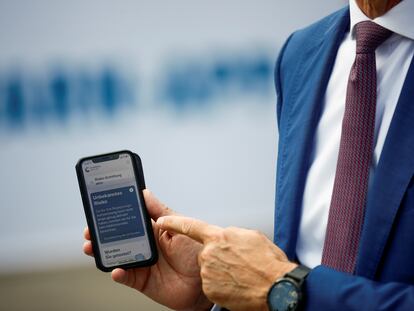 Timotheus Hoettges, CEO de Deutsche Telekom AG, con un móvil provisto de Corona Warn App, la app alemana de rastreo.