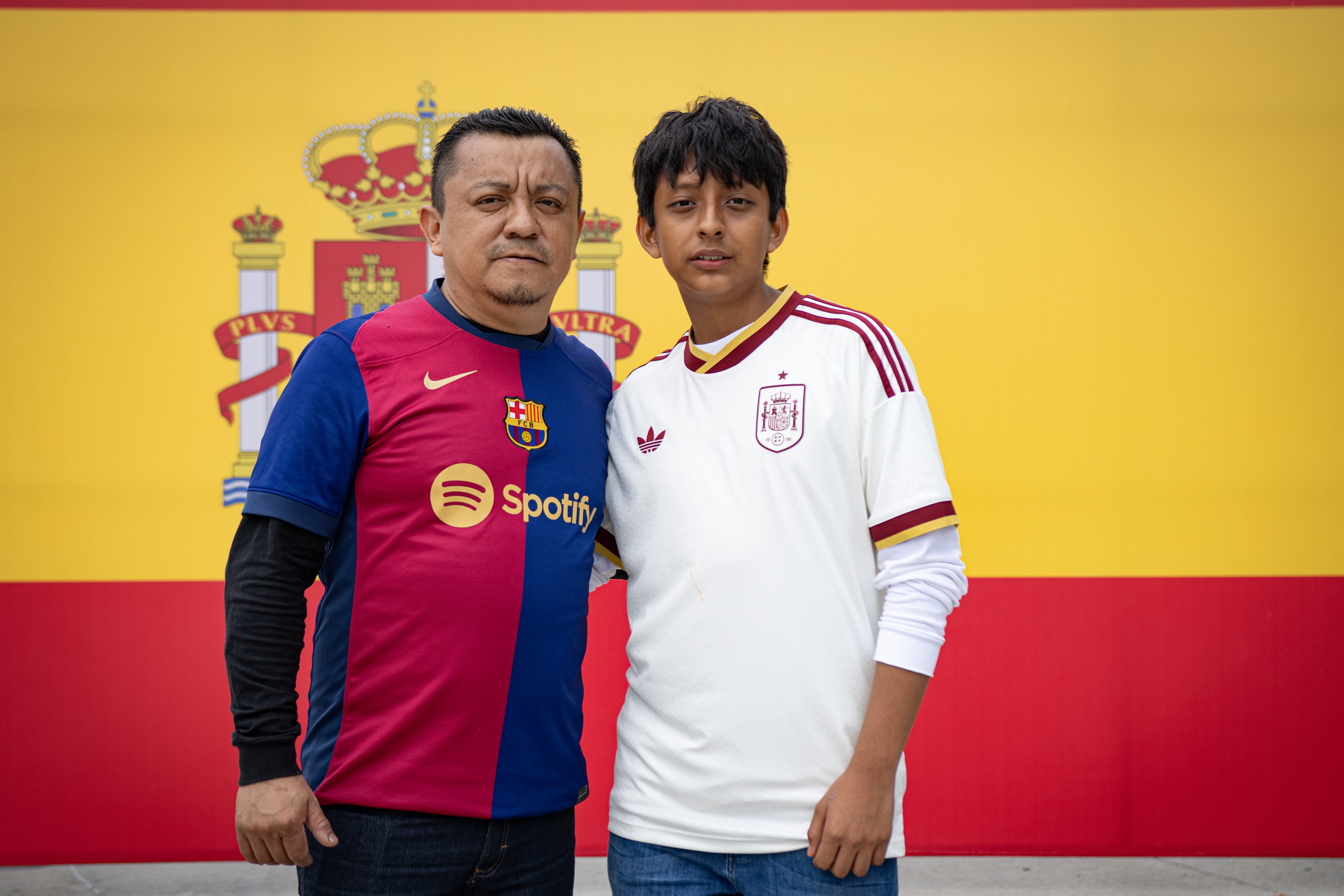 Gabriel Martínez y su hijo Bryan delante de la bandera española.