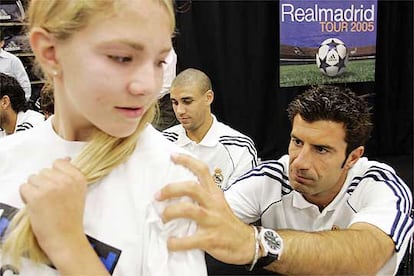 Figo firma la camiseta de un seguidora en la gira del Real Madrid por Estados Unidos.