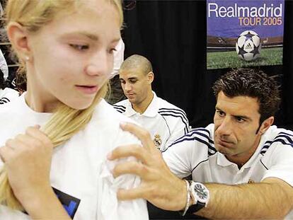 Figo firma la camiseta de un seguidora en la gira del Real Madrid por Estados Unidos.