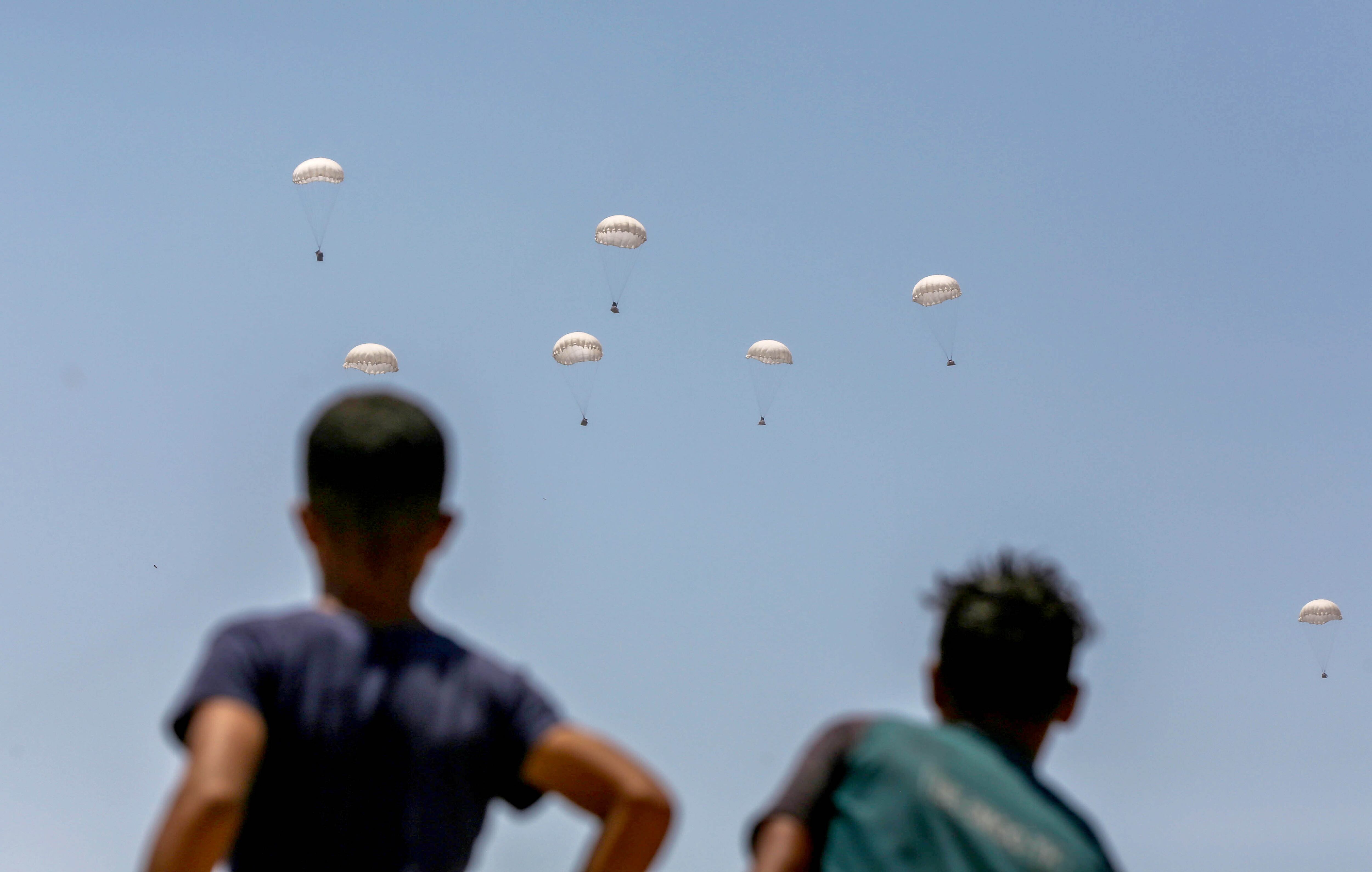 Paquetes de ayuda humanitaria caen del cielo, con la ayuda de paracaídas, este martes en Al Mawasi, en el distrito de Jan Yunis, en Gaza.