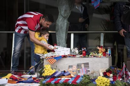 Un hincha con la camiseta del Athletic se acerca con un niño al memorial de Cruyff que el Barcelona ha instalado en el Camp Nou.