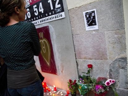 Una mujer mira la foto de Benítez, frente a su casa.