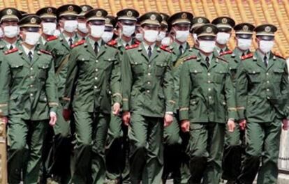 Policías militares desfilan ayer con mascarilla por la plaza de Tiananmen, en Pekín.
/ ASSOCIATED PRESS