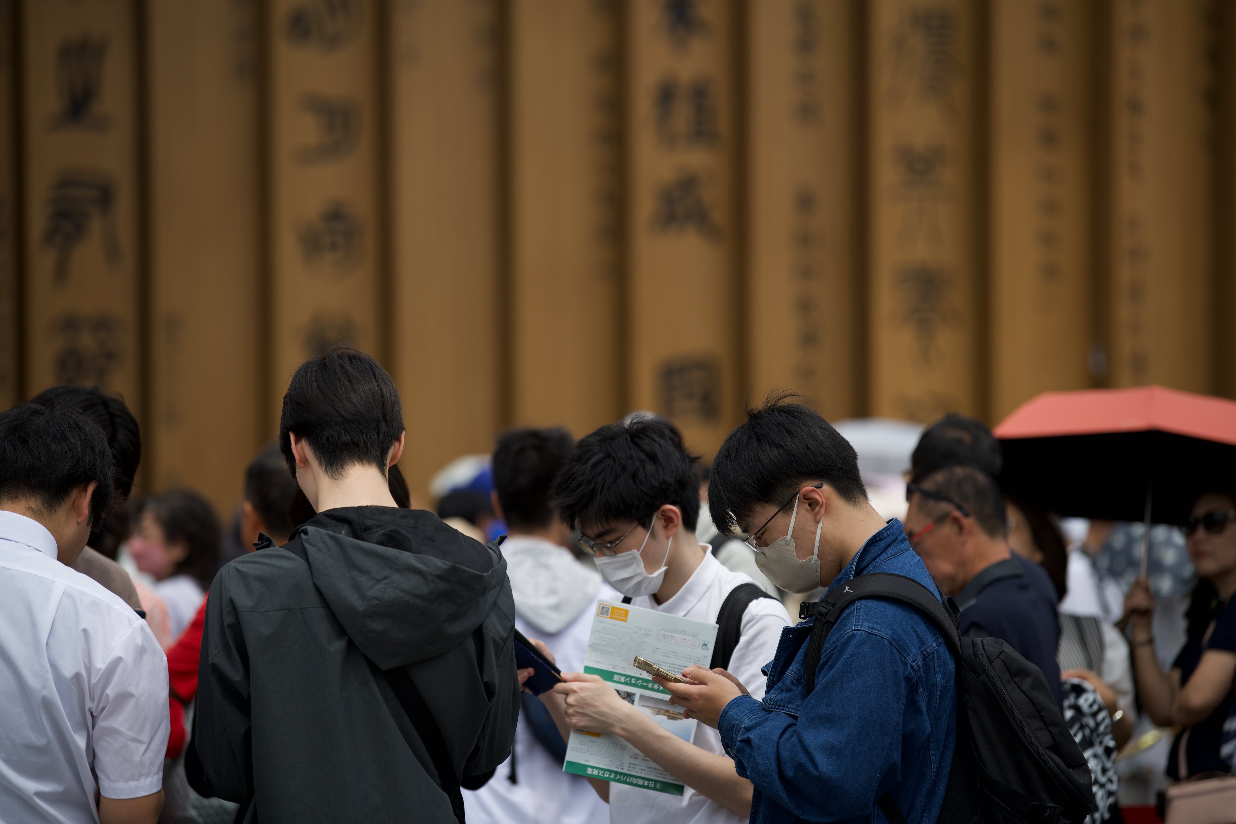 Jóvenes miran sus móviles en la Expo 2025 de Osaka (Japón).