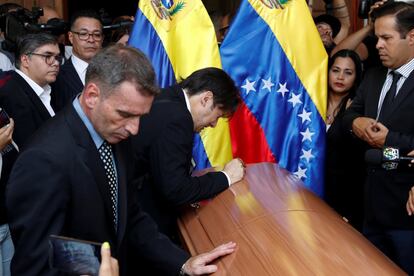 Compañeros del opositor fallecido, Fernando Albán, se lamentan frente al féretro de su muerte, a su entrada a la Asamblea Nacional, en Caracas.