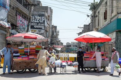 Los vendedores ambulantes esperan la llegada de clientes frente a un mercado cerrado por las autoridades como medida preventiva contra el coronavirus en Rawalpindi (Pakistán). Las autoridades paquistaníes han confirmado más de 223.000 casos de coronavirus, con más de 4.500 fallecidos.
