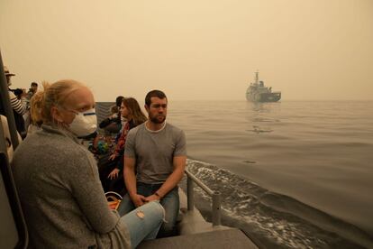 Espera-se que a operação resgate os 4.000 moradores e turistas que ficaram presos por dias em uma praia em Mallacoota, no estado de Victoria. Na foto, um grupo de evacuados é transferido para um navio da marinha australiana.