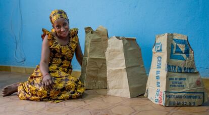 Kadidiatou Touré posa con algunos vestidos de cartón confeccionados por ella.