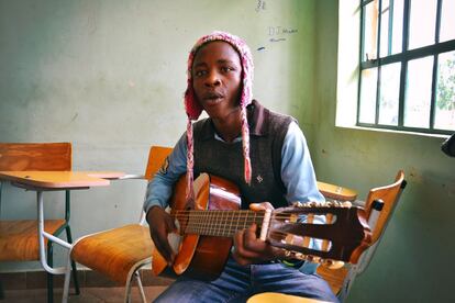 Un alumno de la escuela de música de Amref aprende a tocar la guitarra.