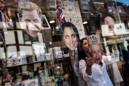 Un trabajador de una tienda organiza máscaras que representan a miembros de la familia real en una tienda antes de la boda.