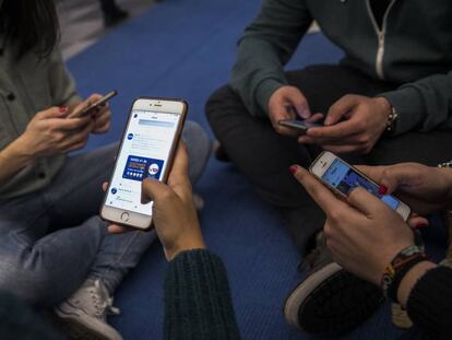 Jovenes viendo redes sociales en su telefono movil. 