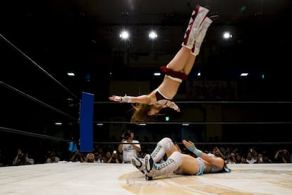 Io Shirai (top) performs a moonsault onto Mayu Iwatani during their Stardom professional wrestling show at Korakuen Hall in Tokyo, Japan, July 26, 2015. Professional women's wrestling in Japan means body slams, sweat, and garish costumes. But Japanese rules on hierarchy also come into play, with a culture of deference to veteran fighters. The brutal reality of the ring is masked by a strong fantasy element that feeds its popularity with fans, most of them men. REUTERS/Thomas Peter    TPX IMAGES OF THE DAY     SEARCH "WOMEN WRESTLERS" FOR THIS STORY. SEARCH "THE WIDER IMAGE" FOR ALL STORIES