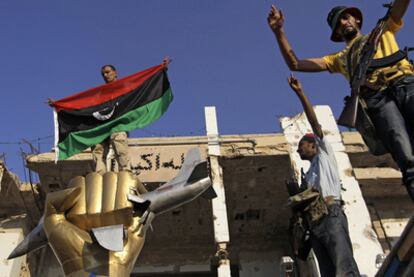 Combatientes rebeldes celebran la toma de Bab el Azizia, el palacio presidencial de Gadafi en Trípoli.