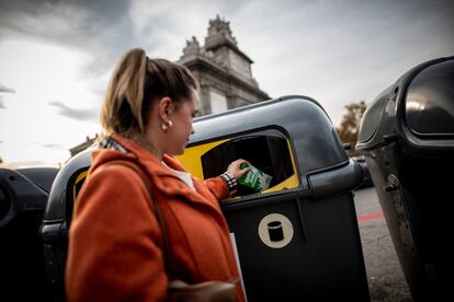 Una mujer tira un envase de papel en un contenedor de basura. FOTO CEDIDA POR ECOEMBES