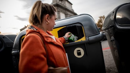 Una mujer tira un envase de papel en un contenedor de basura. FOTO CEDIDA POR ECOEMBES
