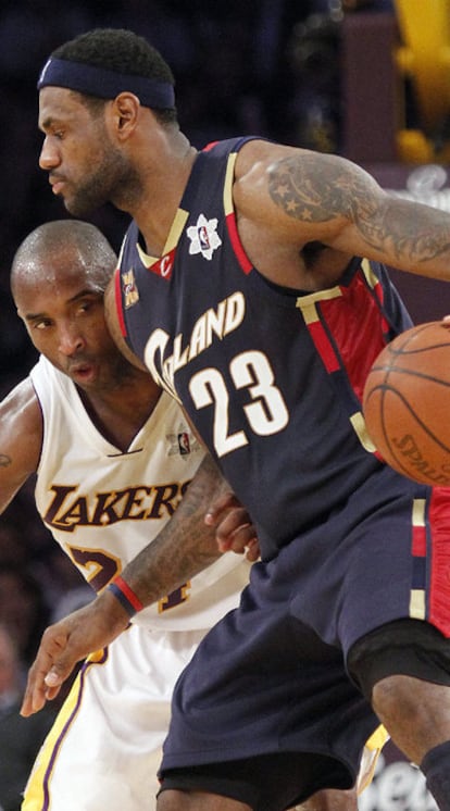 LeBron James protege un balón ante Kobe Bryant.