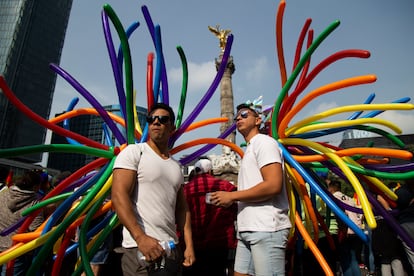 Dos participantes esperan el inicio de la marcha del orgullo LGBTQ en Ciudad de México.