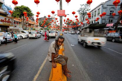 Un hombre se sienta entre linternas chinas y decoraciones para el Año Nuevo Lunar en la Chinatown de Yangon (Myanmar).