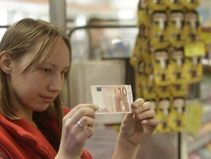Una cajera, con un billete de 10 euros en un supermercado en Riga.