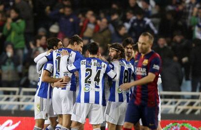Los jugadores de la Real se felicitan, con Iniesta de testigo.