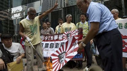 Unos manifestantes de Hong Kong queman s&iacute;mbolos japoneses.