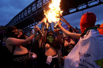 Mujeres prenden antorchas al caer la noche. 