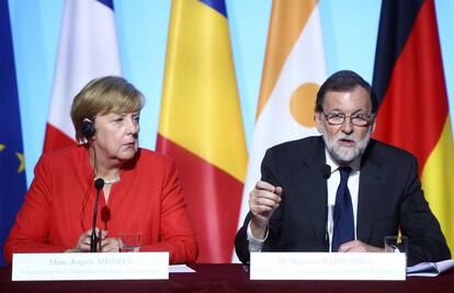 Mariano Rajoy, junto a Angela Merkel, durante una rueda de prensa en Par&iacute;s, hoy.