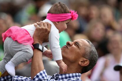 Barack Obama también tuvo tiempo para tomar en brazos a los más pequeños.