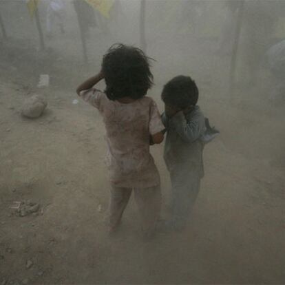Dos niños se protegen del polvo en un ataque en el valle de Swat.