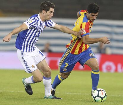 Guedes conduce el bal&oacute;n perseguido por Elustondo, de la Real Sociedad.