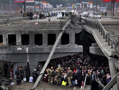 Un grupo de personas intenta pasar por debajo de un puente destruido en Irpin, cerca de Kiev, el pasado marzo, en una imagen tomada por Luis de Vega, uno de los periodistas premiados por la AMI.