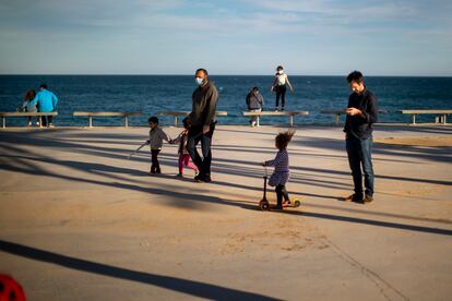 Niños con sus cuidadores en un paseo marítimo de Barcelona el miércoles 29 de abril.