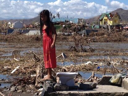 Apple Joy, Filipinas, 2013. Casi seis millones de niños se vieron afectados por el tifón Haiyan. Apple Joy, de 10 años, perdió su casa. No quedó nada, sólo la taza del váter. La cría, sobre los escombros de lo que fue su hogar, recuerda y señala el lugar donde solía jugar con sus hermanas y amigas: el patio donde su madre tendía la ropa. Apple Joy tuvo que vivir con otras 300 personas en un refugio instalado en su antiguo colegio. Allí fue vacunada contra el sarampión y la polio, y recuperó algo de su niñez en un "espacio amigo de la infancia" donde podía jugar.