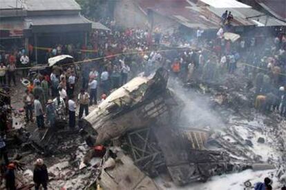 Miembros de los equipos de rescate, bomberos y vecinos de Medan, alrededor del avión siniestrado ayer en el norte de Sumatra.