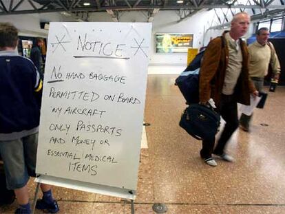 Un cartel informa a los pasajeros de que sólo pueden llevar unos cuantos objetos esenciales como equipaje de mano en el aeropuerto de Belfast, Irlanda.