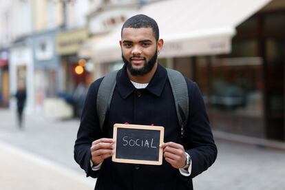 Kevin Ndongala, 22, a student, holds a blackboard with the word "social", the most important election issue for him, as he poses for Reuters in Chartres, France February 1, 2017. He said: "I hear many candidates saying we have too many public sector workers in France, but that's not true. We need them all." REUTERS/Stephane Mahe SEARCH "ELECTION CHARTRES" FOR THIS STORY. SEARCH "THE WIDER IMAGE" FOR ALL STORIES