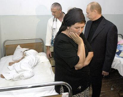 Terroristas chechenos con explosivos adosados a sus cuerpos, asaltan un colegio en Beslan, Osetia (Rusia) y mantienen como rehenes a más de 400 persona entre las que se encuentran más de 200 niños. En la imagen el presidente ruso Vladimir Putin observa a uno de los niños heridos durante el secuestro de la escuela de Beslan, el 4 de septiembre de 2004.