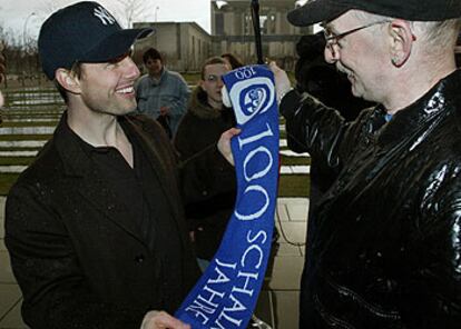 El actor Tom Cruise saluda a un alemán que le regaló la bufanda de su equipo de fútbol, el Schalke.