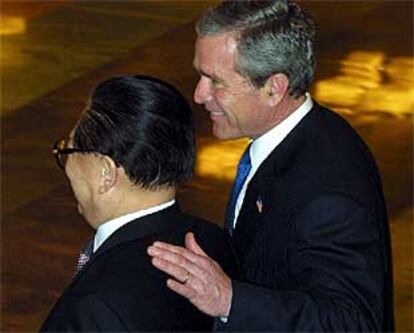 El presidente de EE UU, George Bush (derecha), con su homólogo chino, Jiang Zemin, ayer en Pekín.