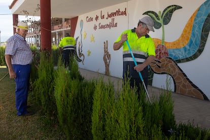 Dos trabajadores limpian los alrededores de la casa de la juventud de Saucedilla, el pasado miércoles.