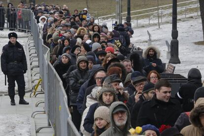 Un policía vigila a la multitud de personas que se congregó en las inmediaciones del Centro Sájarov de Moscú para rendir homenaje al líder opositor ruso, Boris Nemtsov, asesinado el pasado viernes en circunstancias aún no esclarecidas.