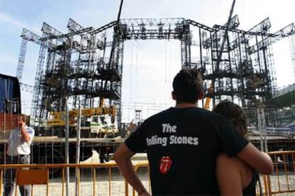 Dos seguidores del grupo miran cómo desmontan el escenario de El Ejido.